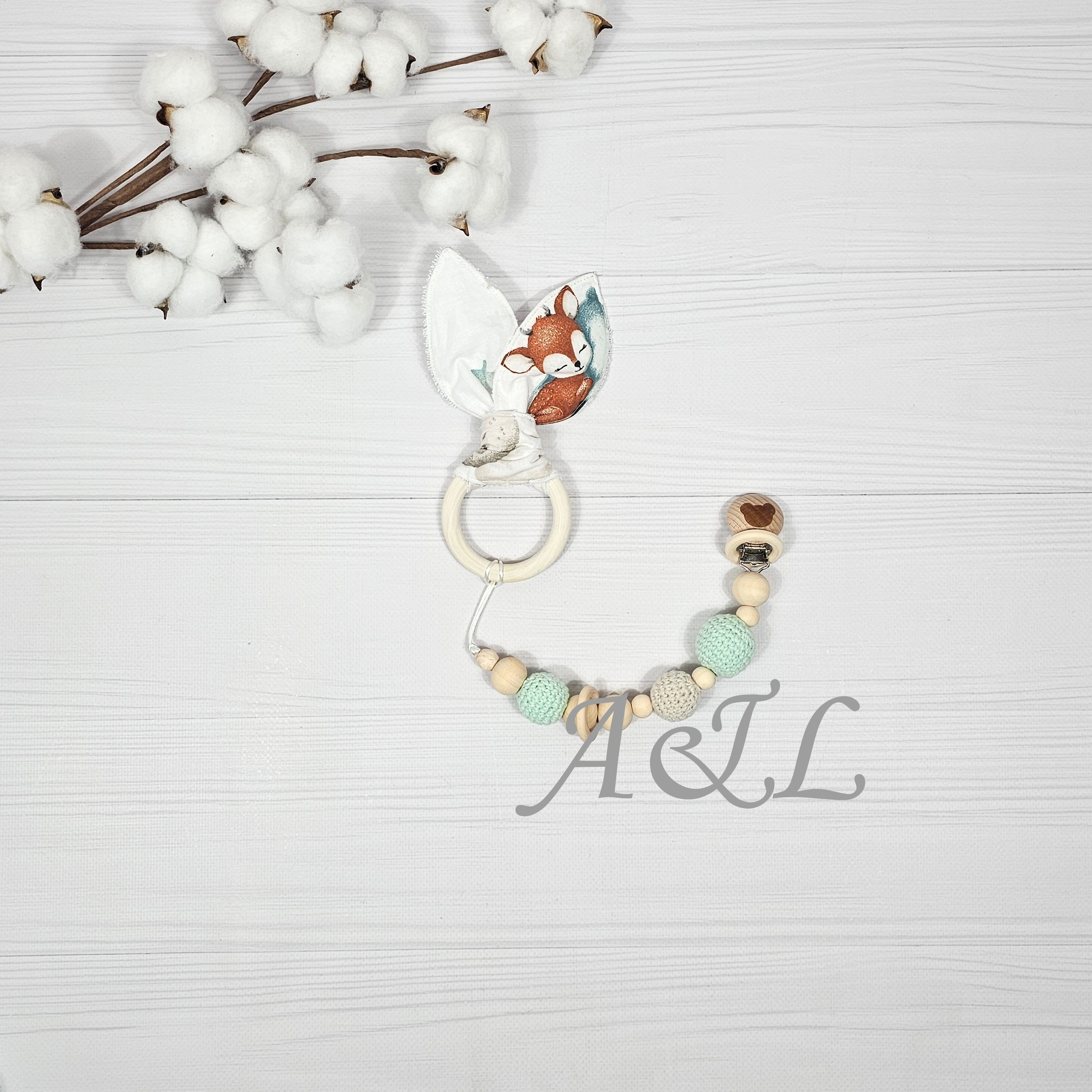 Дитячий гризунець з дерев'яними елементами та тримачем з дерев'яними та в'яаними намистинами Дитячий Еко гризунок «Шарудливі вушка» з тримачем, гризункць із текстильною частиною у формі вушок та дерев'яними елементами, та тримач для соски з в'язаними та дерев'яними намистинами