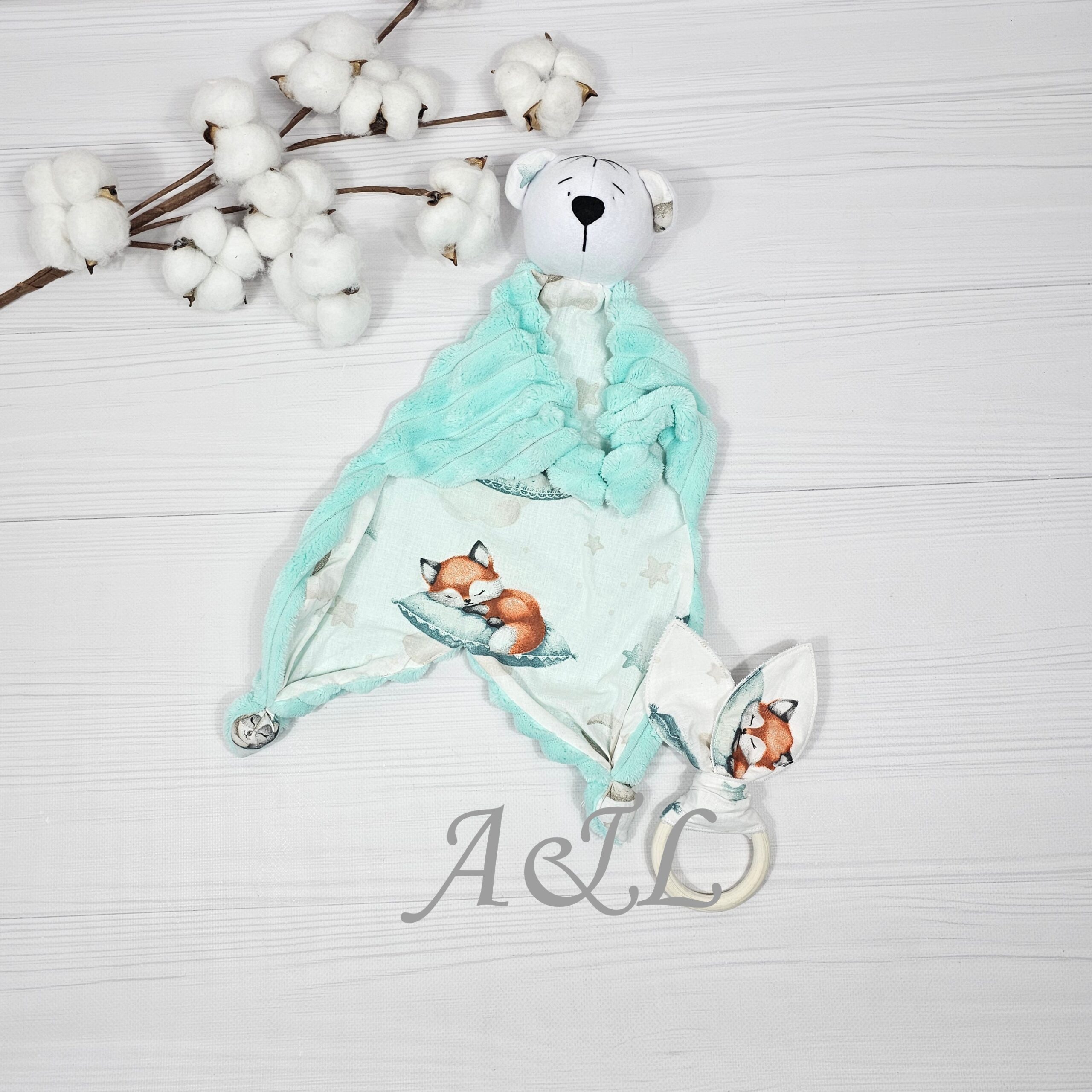 Іграшка-комфортер "Ведмедик" з принтом зайчиків з іграшками і еко-гризунка Іграшкфа-комфортер і еко-гризунок. Іграшка-комфортер у вигляді ведмедика з м'якої тканини з принтом звірят на подушкахі та еко-гризунка на дерев'яному кільці.